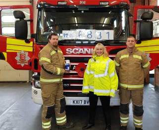Fire fighter presenting money to fundraiser