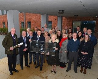 Staff and volunteers from Havens Hospices with Barnes Construction holding the time capsule