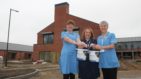 Three Fair Havens nurses hold a fundraising bucket in front of the new hospice