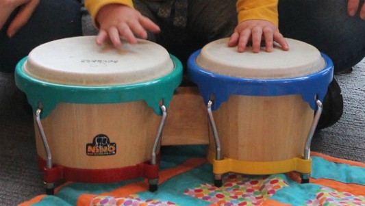 Child hitting drums on floor