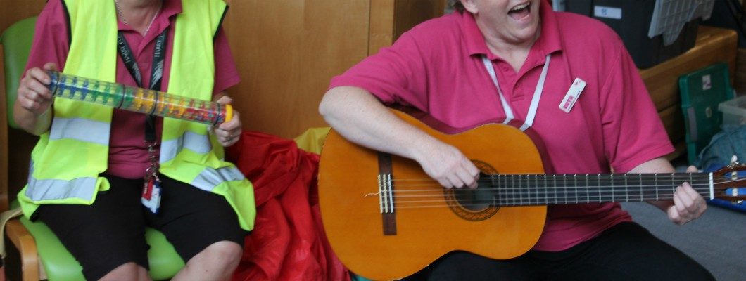 Ruth holding her guitar at sensory storytime