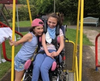 Connie on the wheelchair swing with sister
