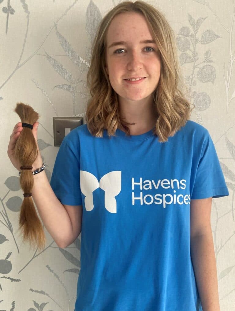 Sadie holding her hair that was cut off for her fundraiser