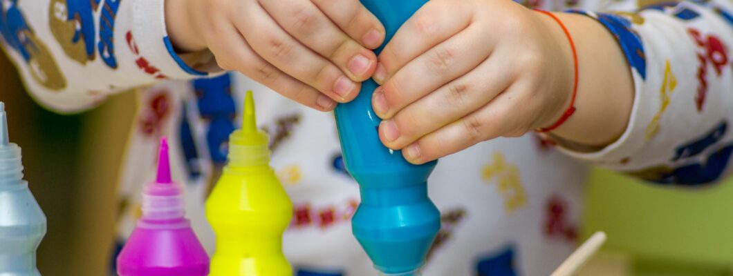 Kids hand squeezing paint