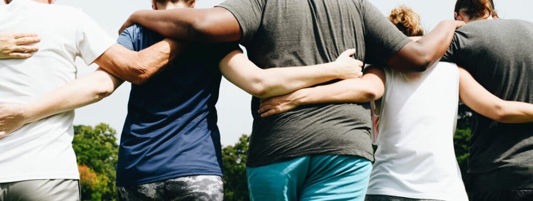 group of people walking along linking arms across their back