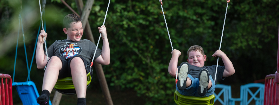 Two brothers on the swings together at Little Havens