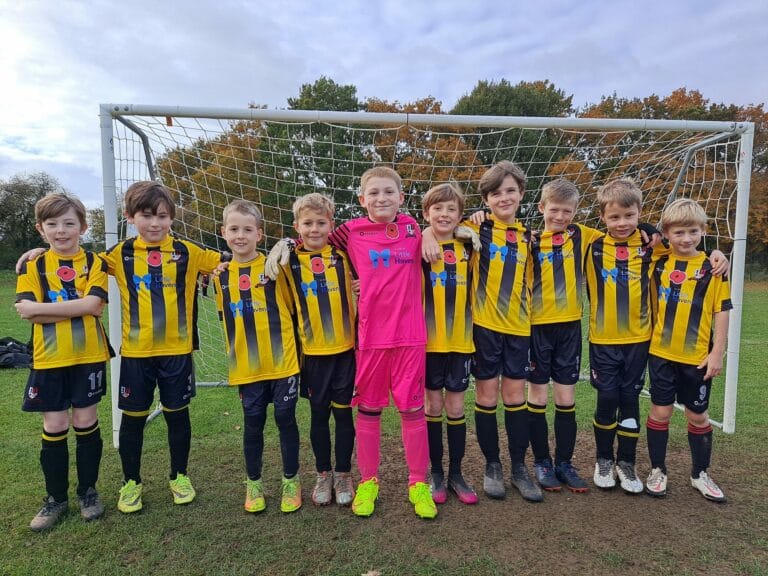 Broomfield Tigers U9s Team Supporting Little Havens - the team standing in front of a goal on a football pitch