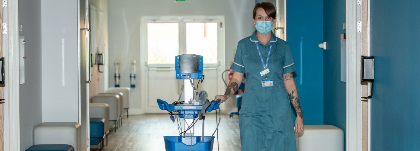 FH Nurse Maria walking in corridor at the hospice