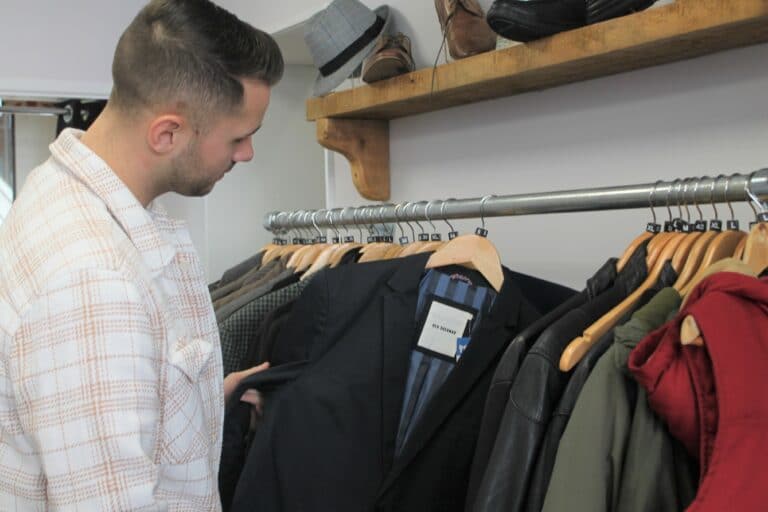 person looking through clothing rail in Havens Hospices' Leigh Shop