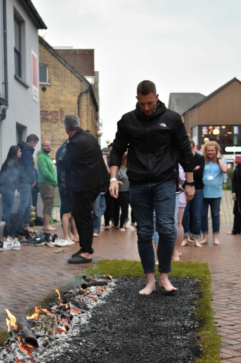 Man walking on hot embers for charity fire walk event