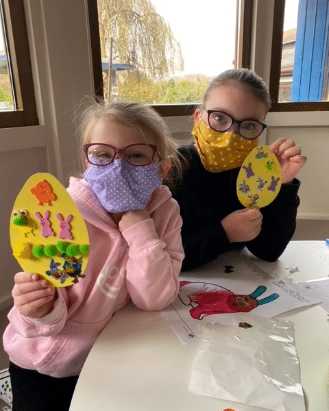 Siblings holding up their Easter Egg Crafts