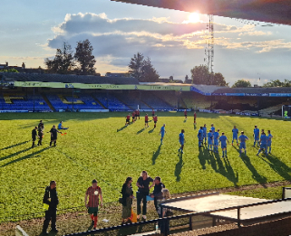 Football players running across a football pitch