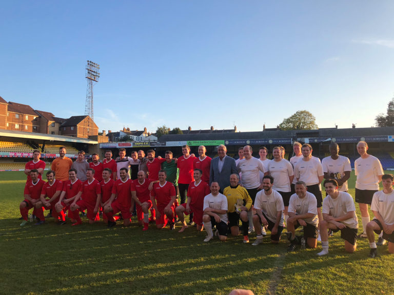 Group of people with football kits on a football pitch