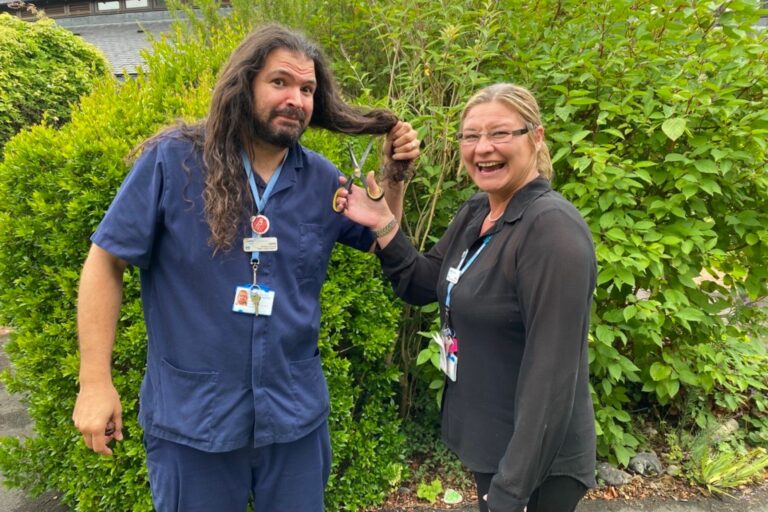 Woman with scissors pretending to cut a man's long hair