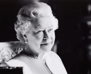 Black and white photo of the queen looking across the room