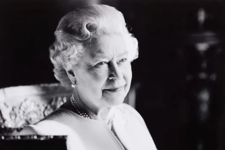 Black and white photo of the queen looking across the room