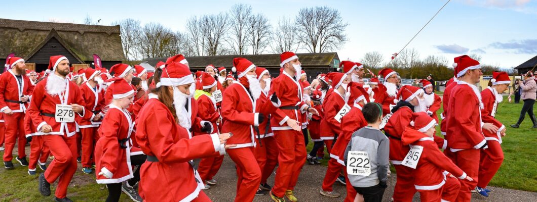 A crowd of runners wearing santa suits and hats