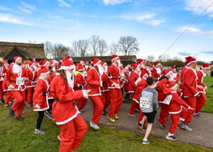 A crowd of runners wearing santa suits and hats