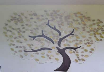 The leaves of life tree display on a large white wall