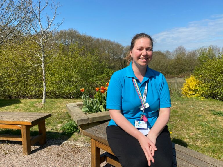 Lauran Boulton sitting on a bench in a garden