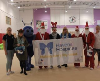Group of people from South Essex Gymnastics dressed in Santa suits and Betsy the Havens Hospices Mascot