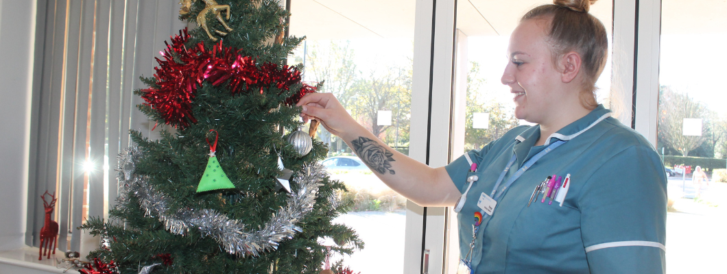 Fair Havens Nursing Assistant adding decoration to tree