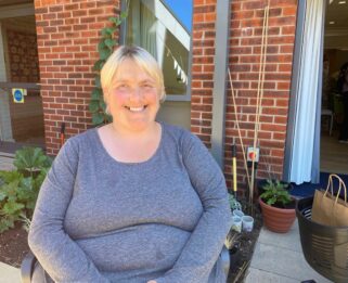 Amanda sat outside in the garden at Fair Havens smiling