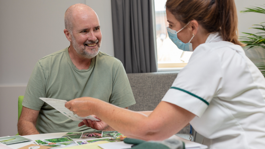 Occupational therapist talking to a patient sat down together in the lounge