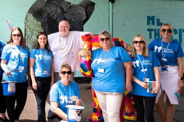 Havens Hospices employees with artist John Bulley standing with Duke the patchwork elephant