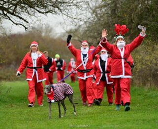 People dressed up at Santa running in a field