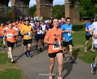 People running through Central Park in Chelmsford just past the railway bridge