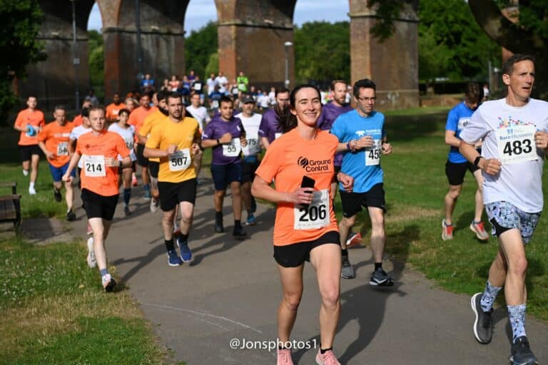 People running through Central Park in Chelmsford just past the railway bridge