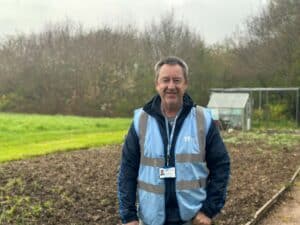 Neil Oakley standing in front of the allotments at Little Havens