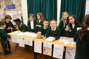 Pupils of a primary school standing behind tables at a fundraising fair