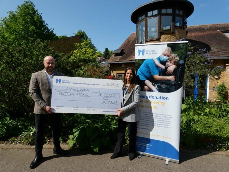 Ross Brewer and Rossella holding a large cheque outside Little Havens Hospice