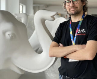 Artist Peter Cass, standing next to a blank elephant sculpture