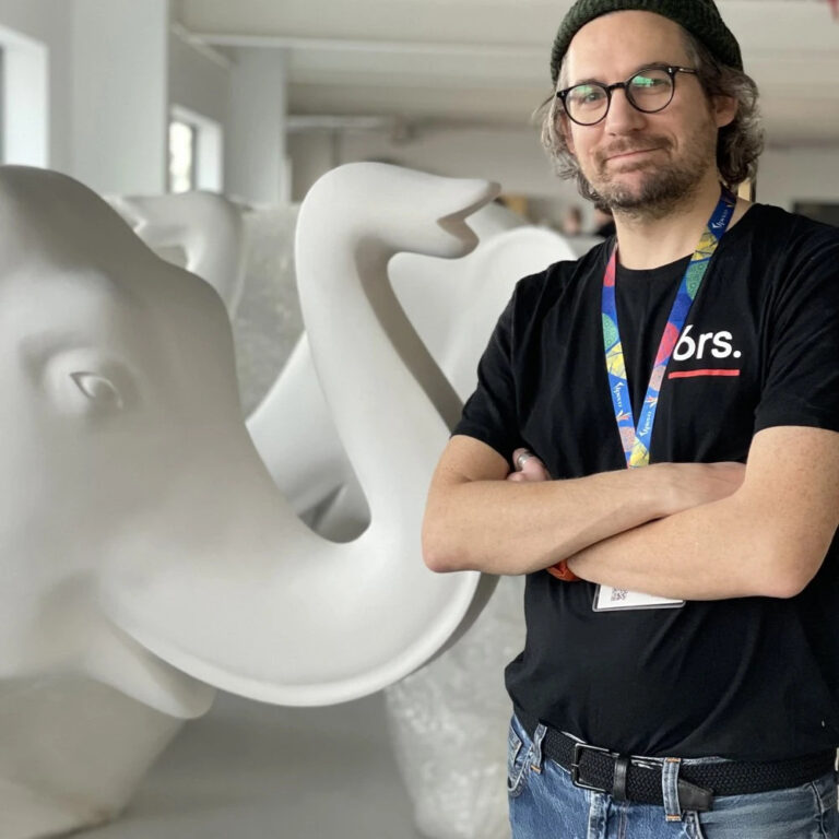 Artist Peter Cass, standing next to a blank elephant sculpture