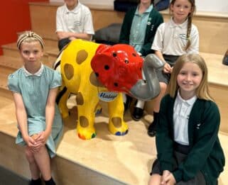 Richmond Avenue Primary School pupils sitting next to their baby elephant sculpture