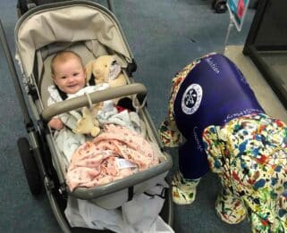 Baby Robyn in a pram next to a decorated baby elephant sculpture