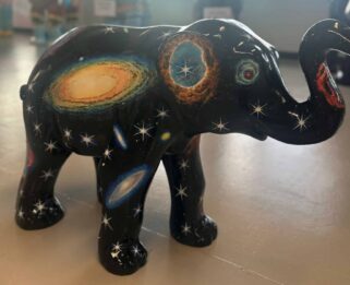 A small elephant sculpture with a stars and space themed design.