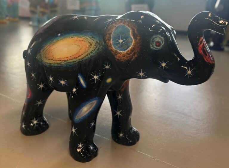 A small elephant sculpture with a stars and space themed design.