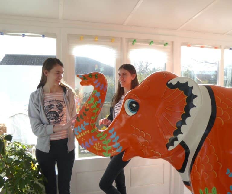 Rachael & Phillippa Corcut standing next to an elephant decorating as an orange clownfish