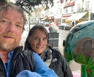 Steve and Cara Ayers standing next to an elephant sculpture