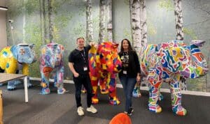 Staff at AJ Chambers standing with four elephants from Herd In The City