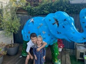 Two children standing with elephant Summer Meadow