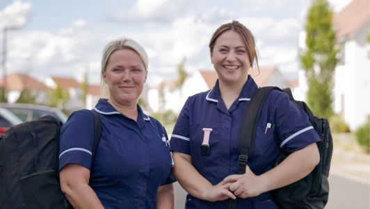 Two smiling Havens Hospices nurses in blue uniforms