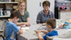 A woman and two children taking part in art therapy, joined by a Fair Havens Care Team member