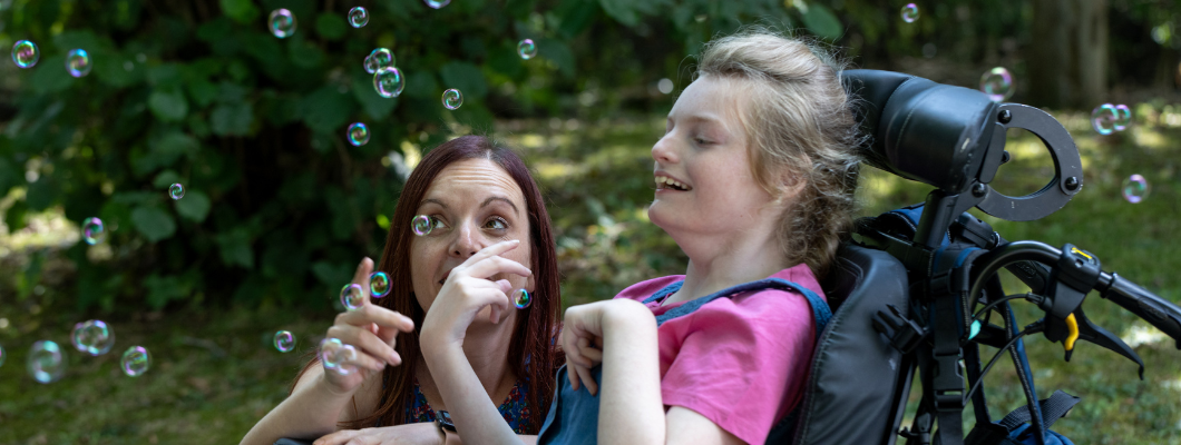 A little girl with her mum playing with bubbles in Little Havens garden