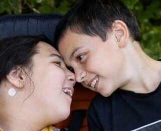 Alyssa and brother Ethan smiling at each other with their faces touching