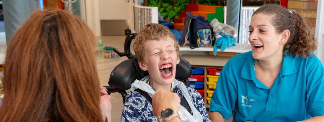 Young boy laughing with Little Havens nurse